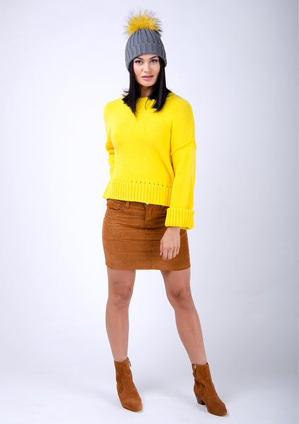 Brown cord mini skirt paired with bright yellow knit sweater and cute bobble hat.
