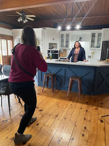 Photographer taking a photo of a business women in a lifestyle kitchen setting