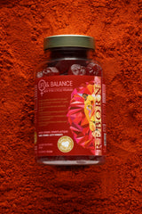 A bottle of food supplement placed on a background of saffron powder