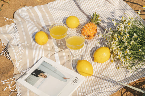 Lemons and lemonade on a picnic blanket.