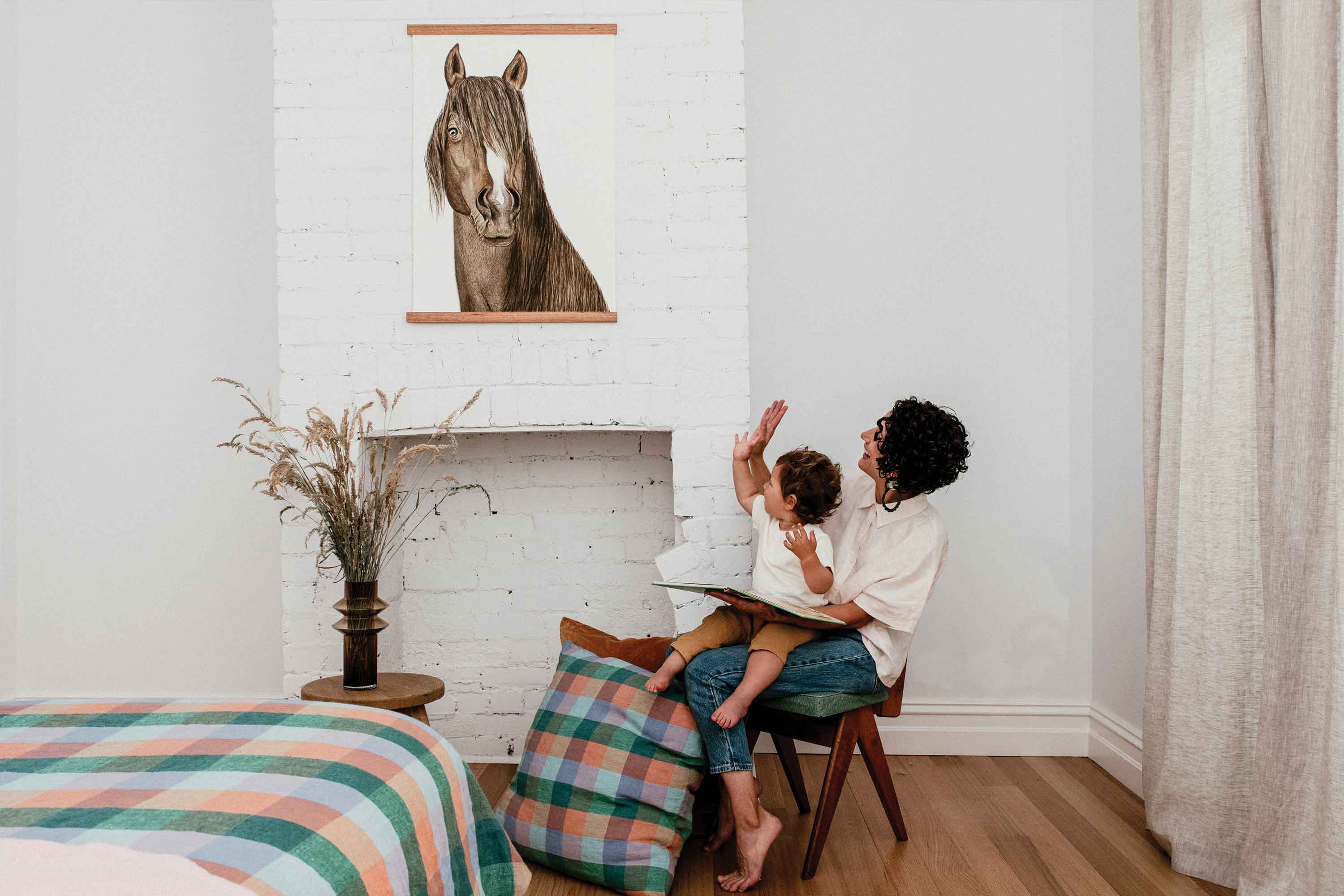 mum and son pointing to a large horse watercolour artwork 