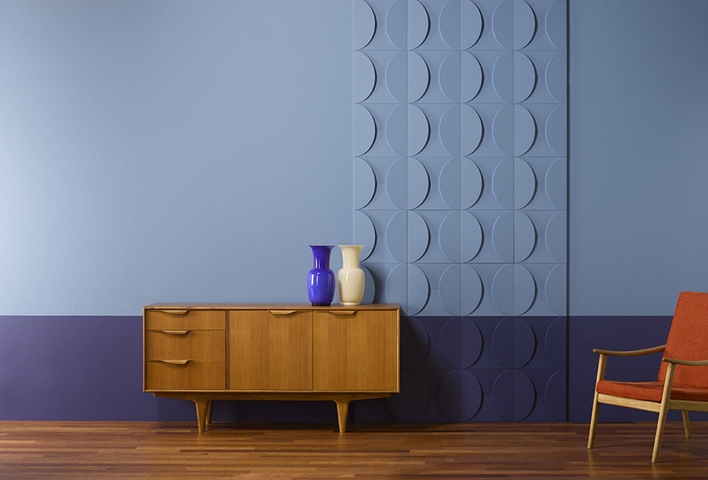 A wall painted to shades of blue with 3D wall panels