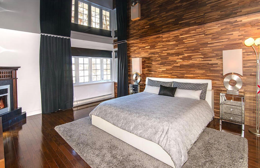 A walnut wood wall installed behind a bed in bedroom