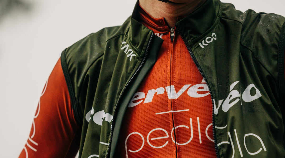 Close up of image of a cyclist wearing a red jersey and green gilet