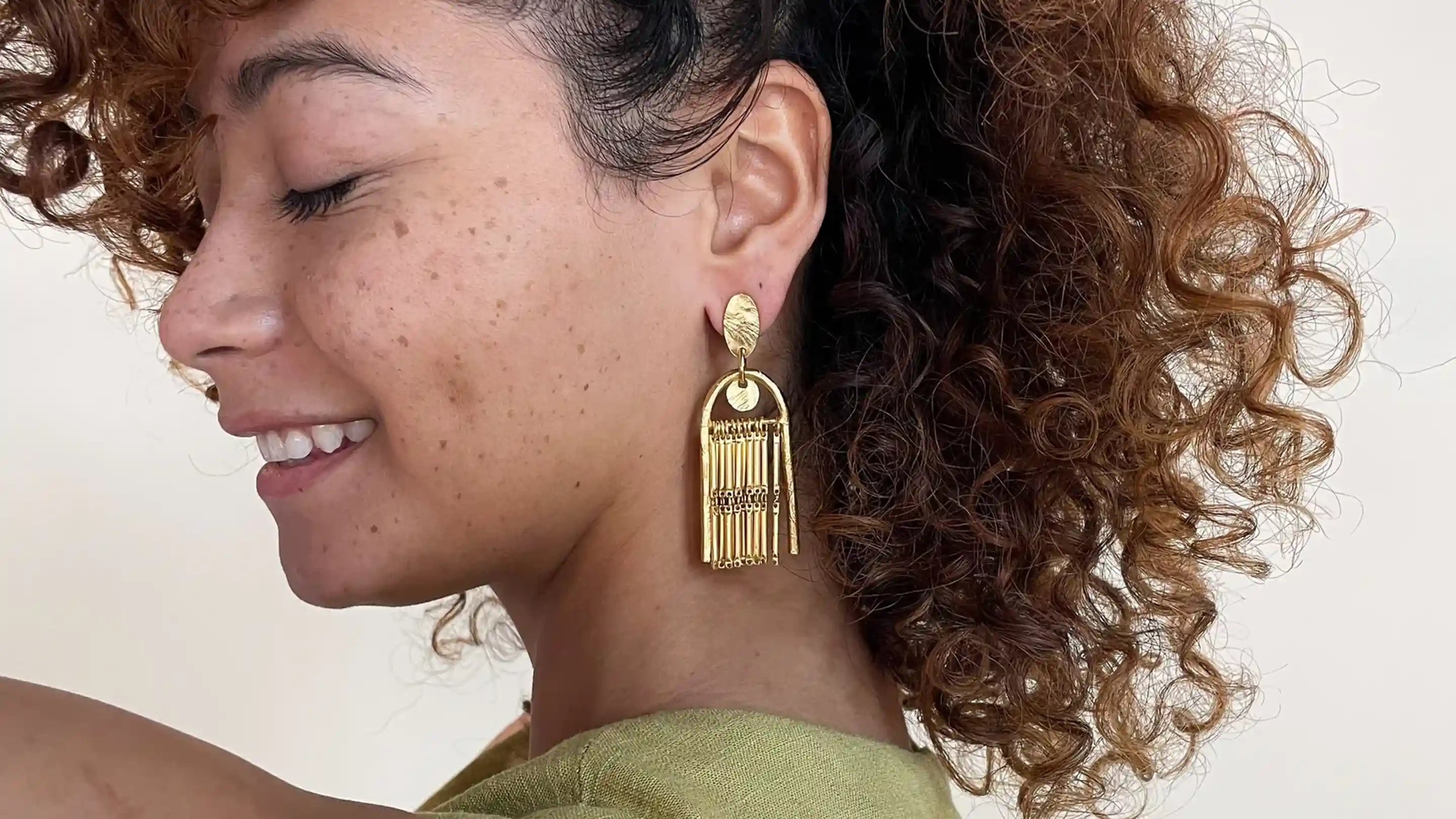 A model wearing gold fringe earrings from Lingua Nigra