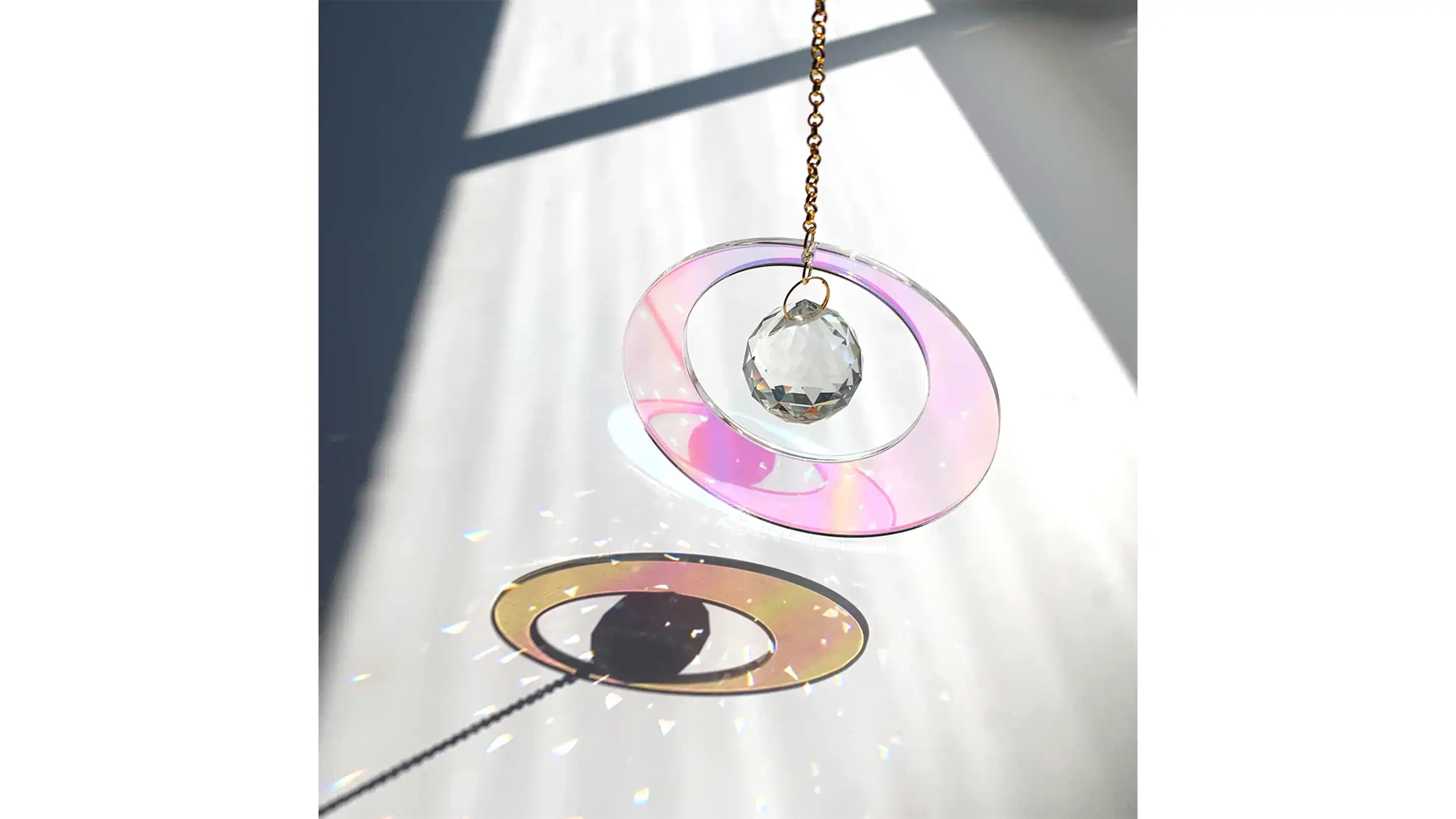 A sun catcher orb and glass circle reflecting sunlight onto a floor