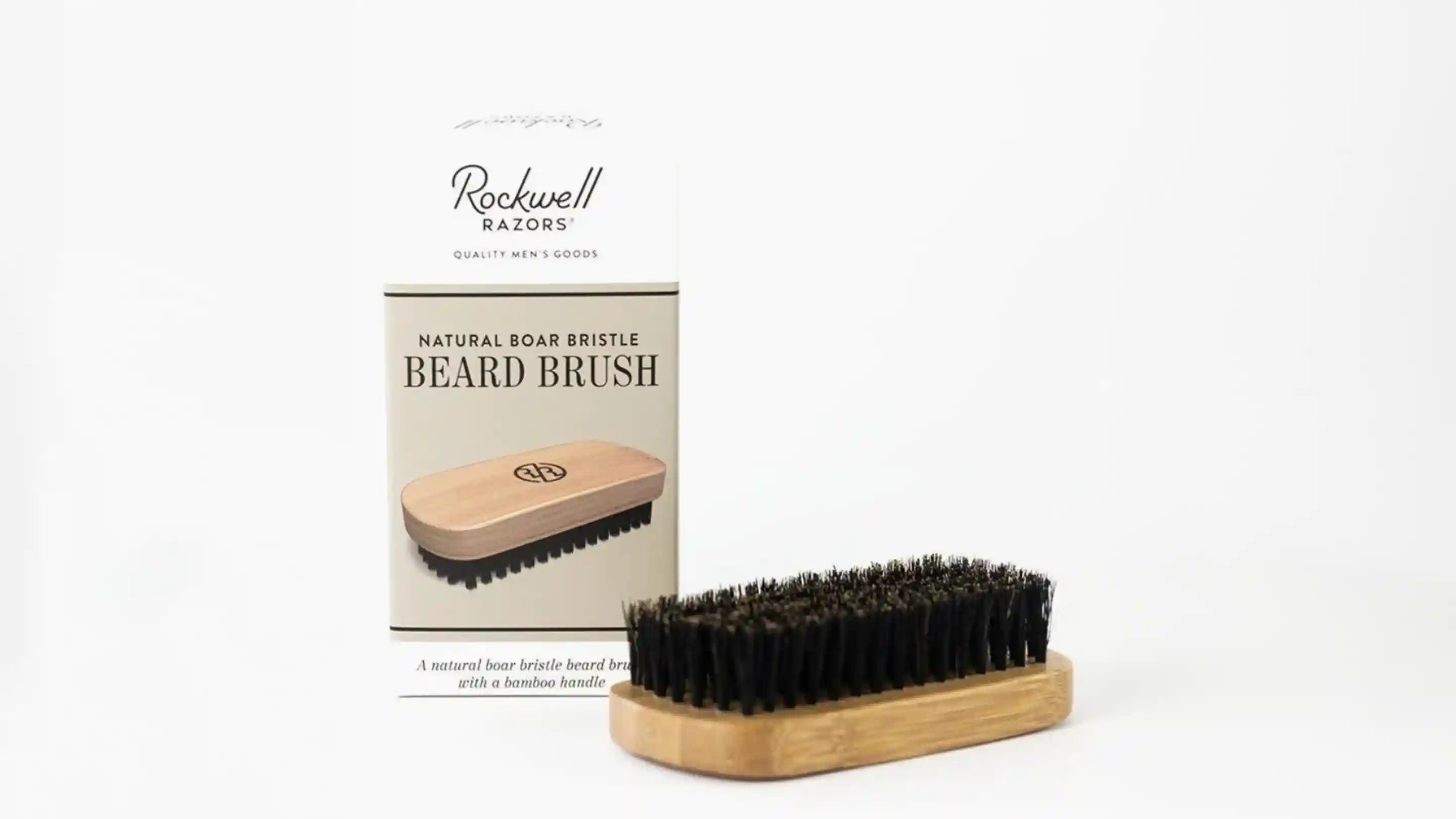 A beard brush in front of it's packaging box