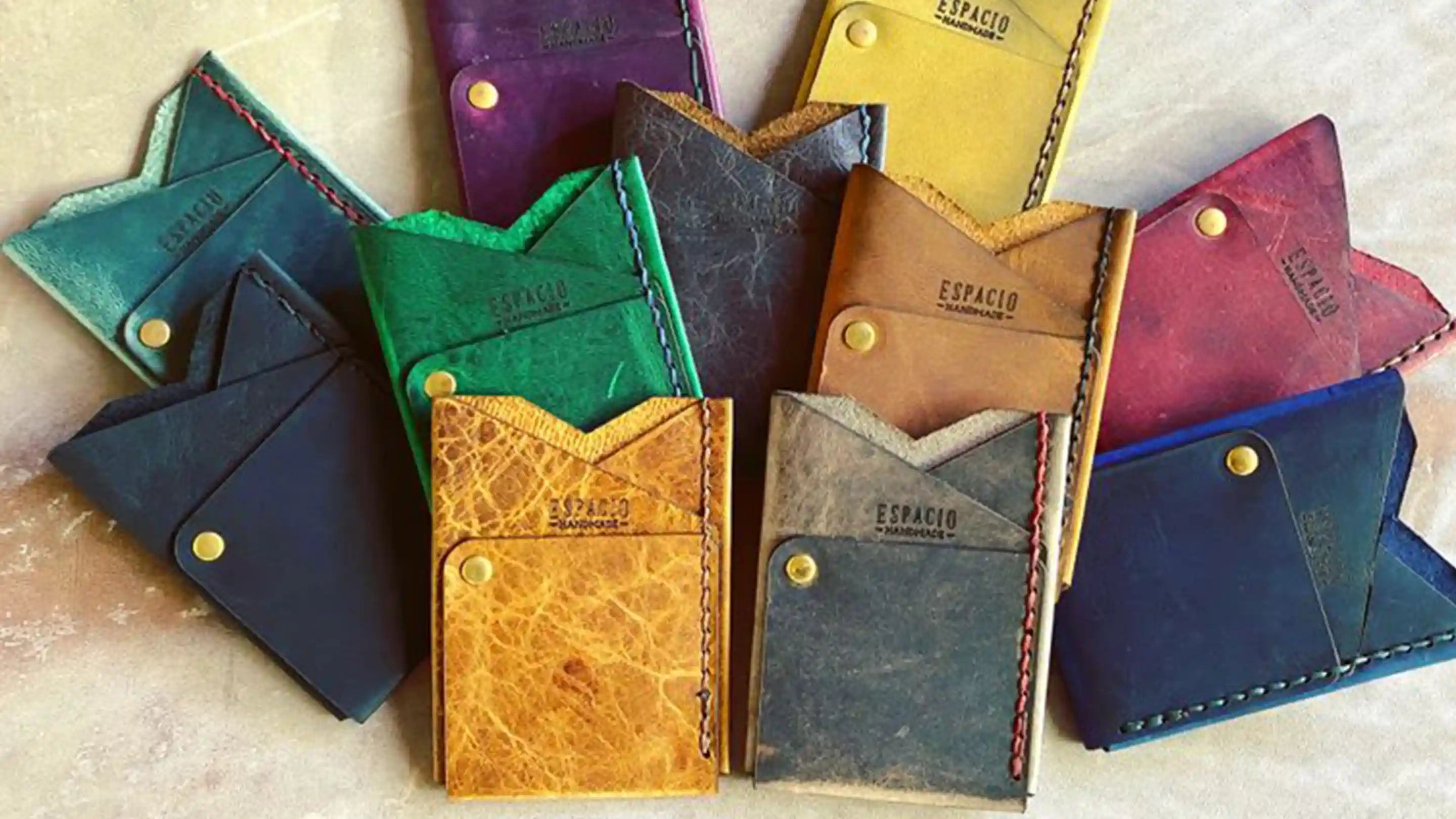 Multiple multi-colored leather wallets laying on top of each other