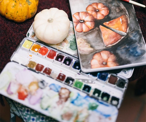 watercolor paint pallet with small painting of pumpkins and pumpkin pie