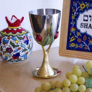 Gold kiddush cup with pomegranate design and saucer