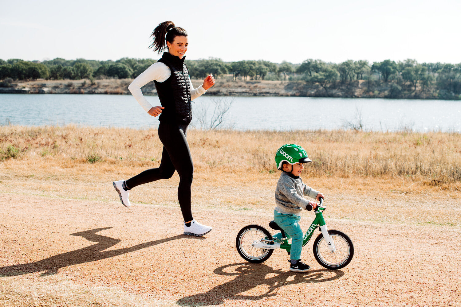 Mother running with child on a woom 1 bike