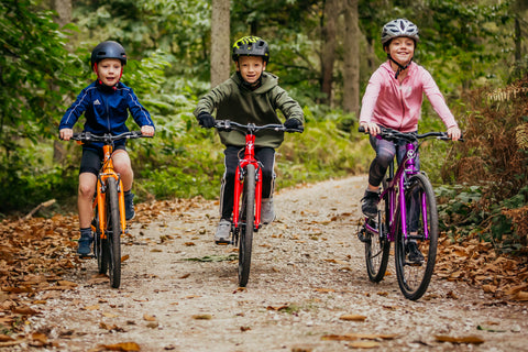 three kids riding bikes wearing the well-fitted bike helmets