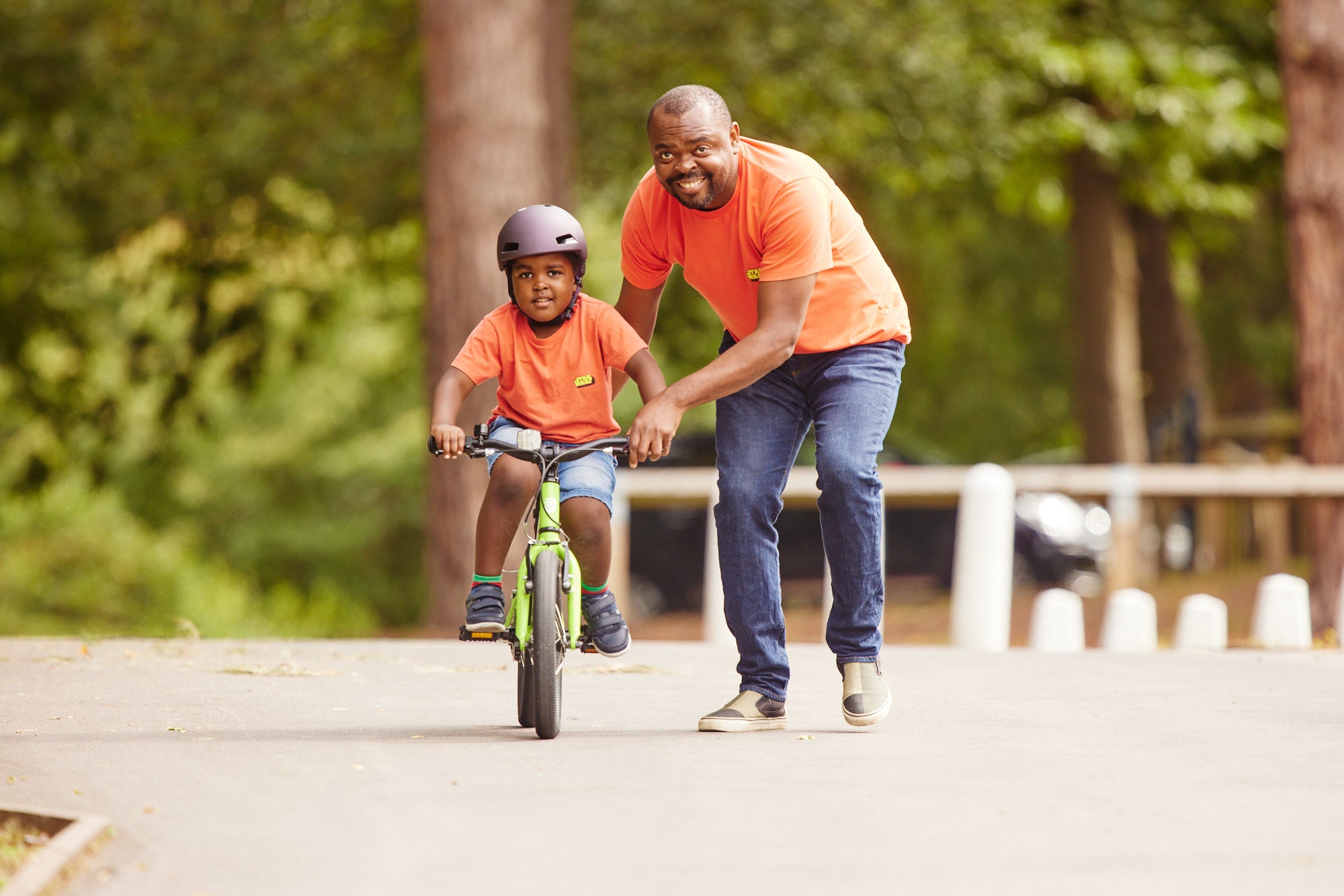 A father helping his son to learn how to ride a bike