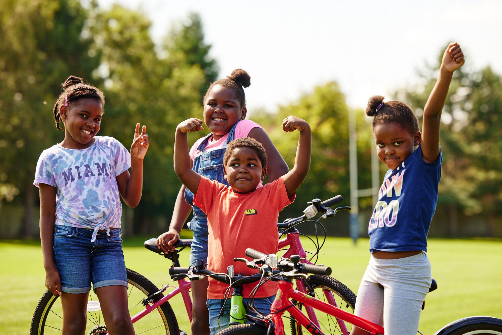 several kids looking very happy on their bikes
