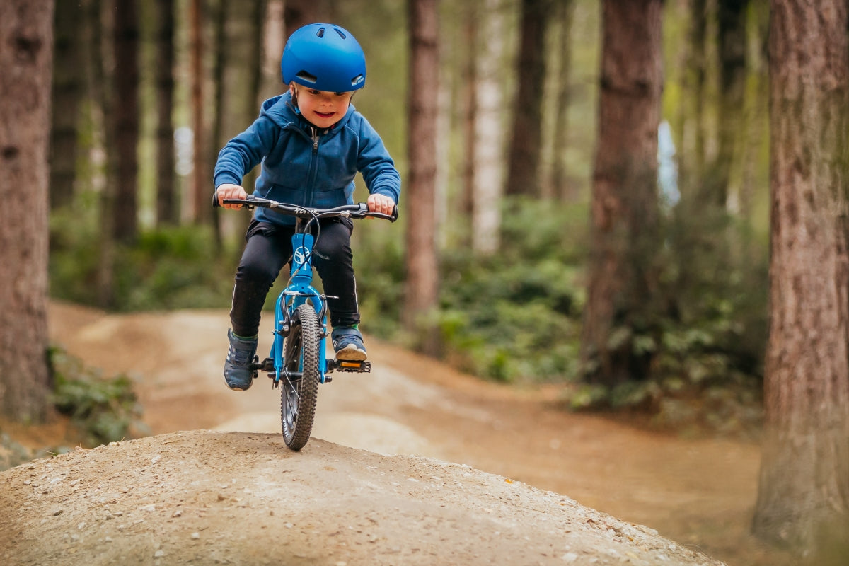 child on first pedal bike off road - bike club