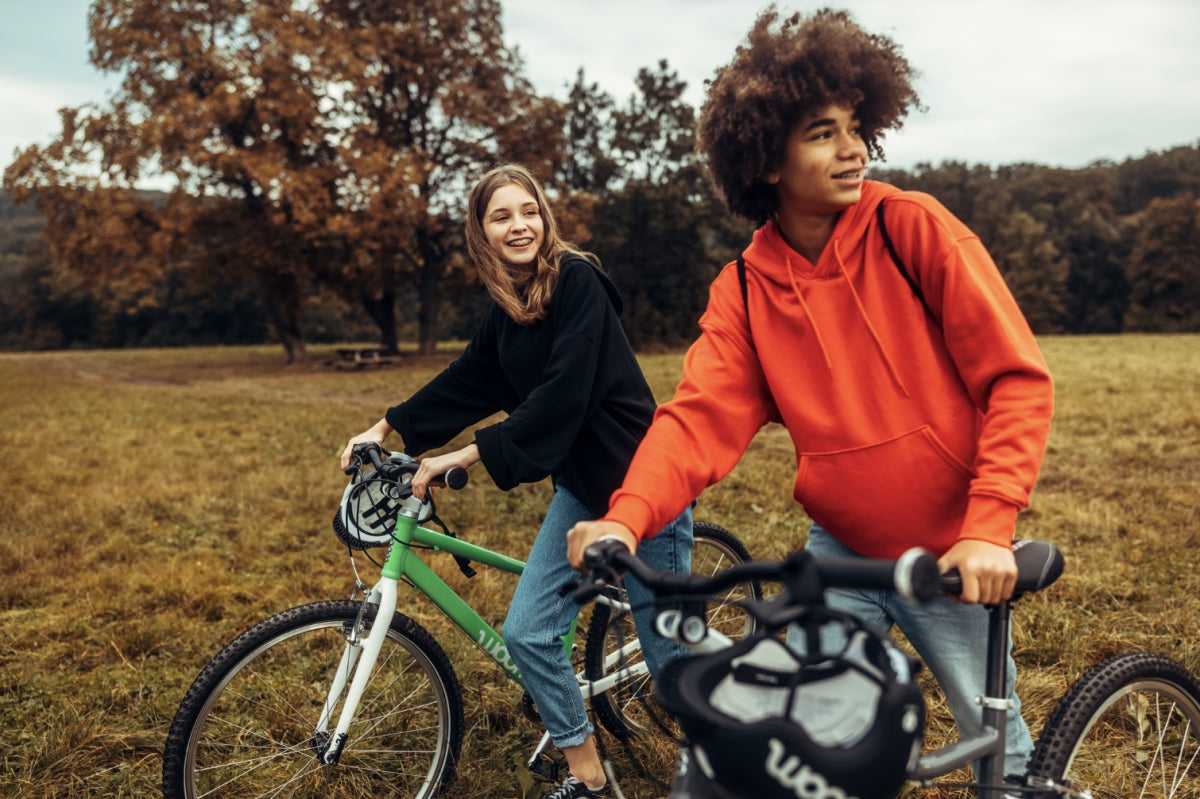 two kids on woom bikes in a park - bike club