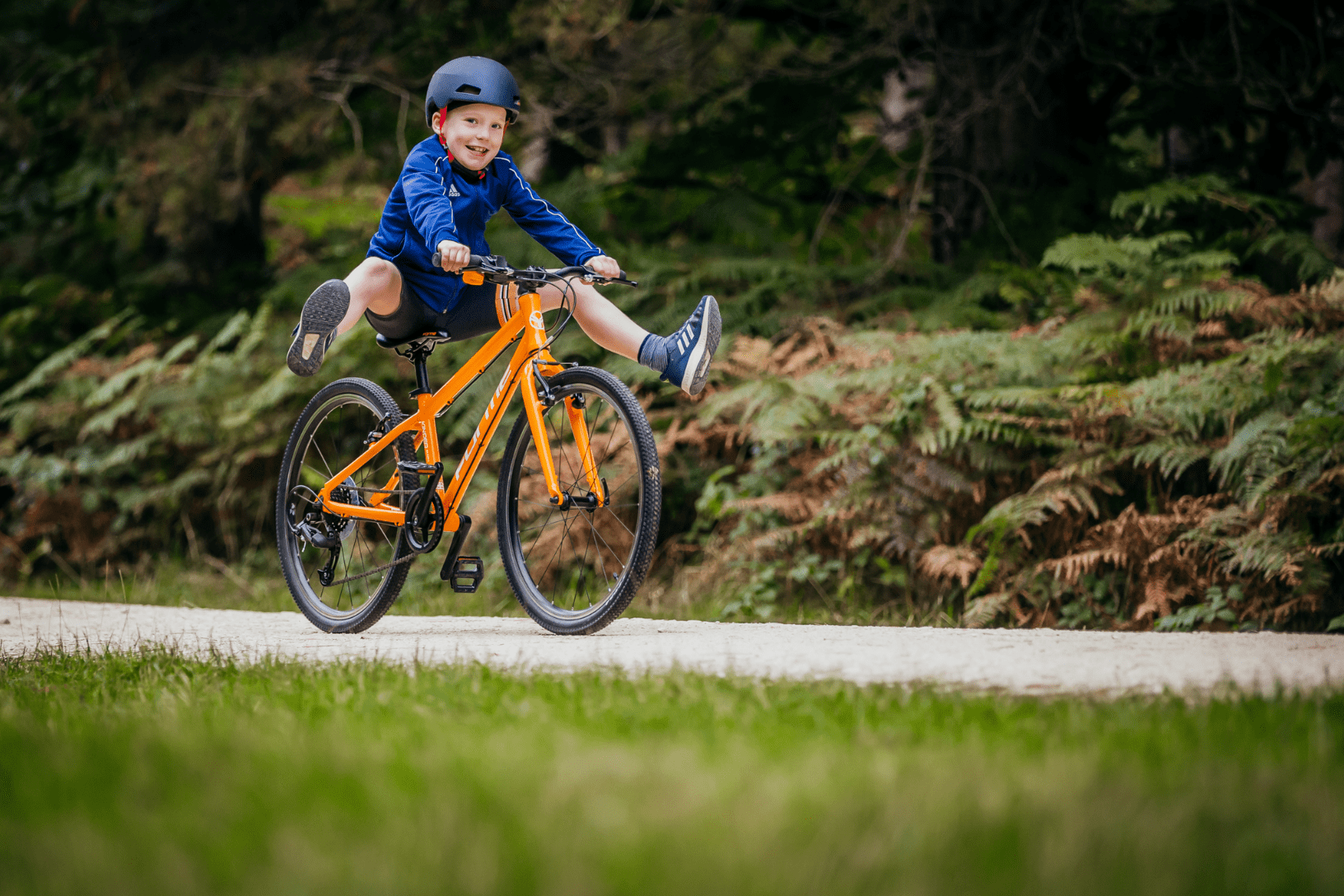 child riding on orange forme bike - bike club