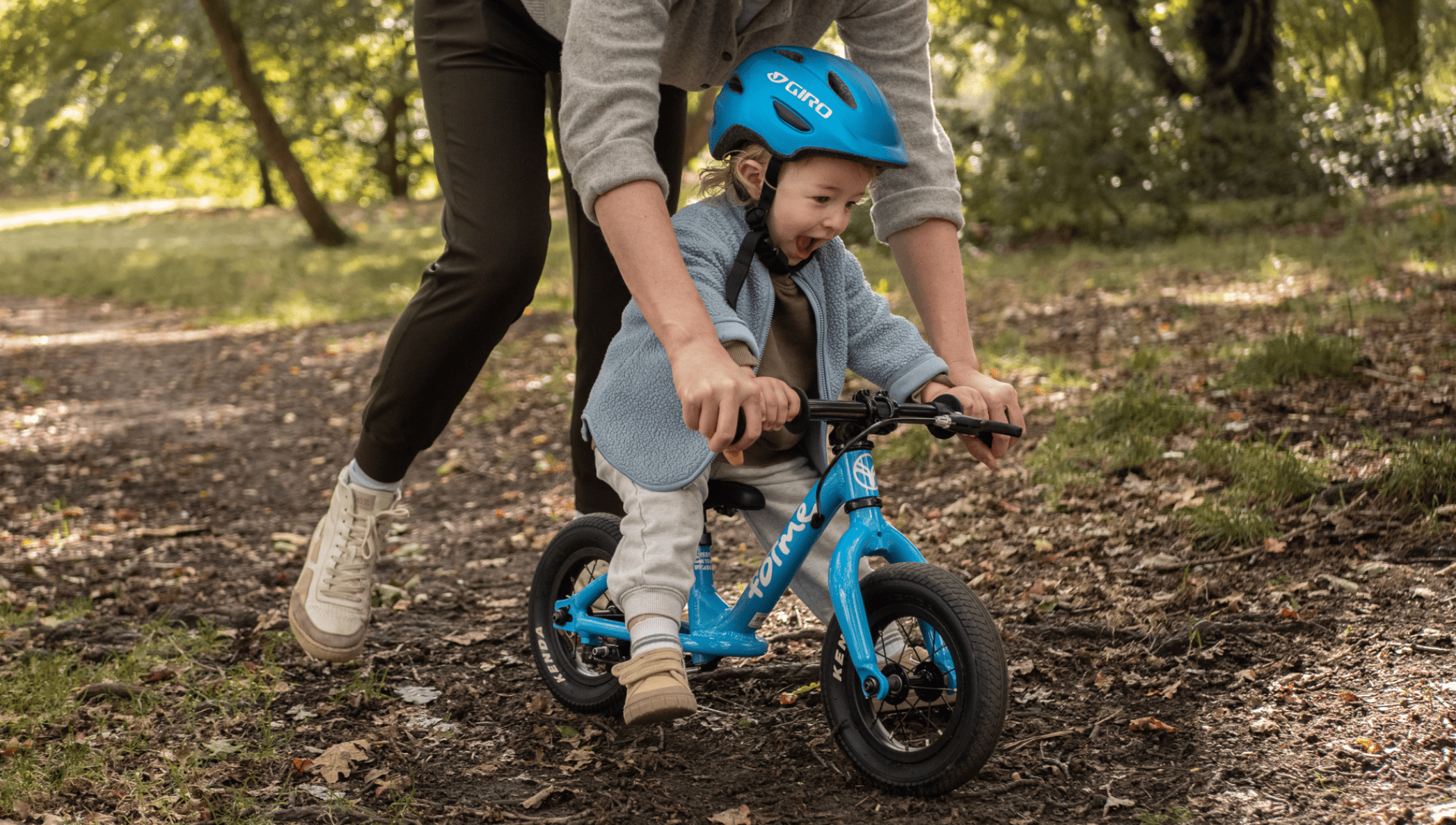 parent helping a child with a balance bike - Bike Club