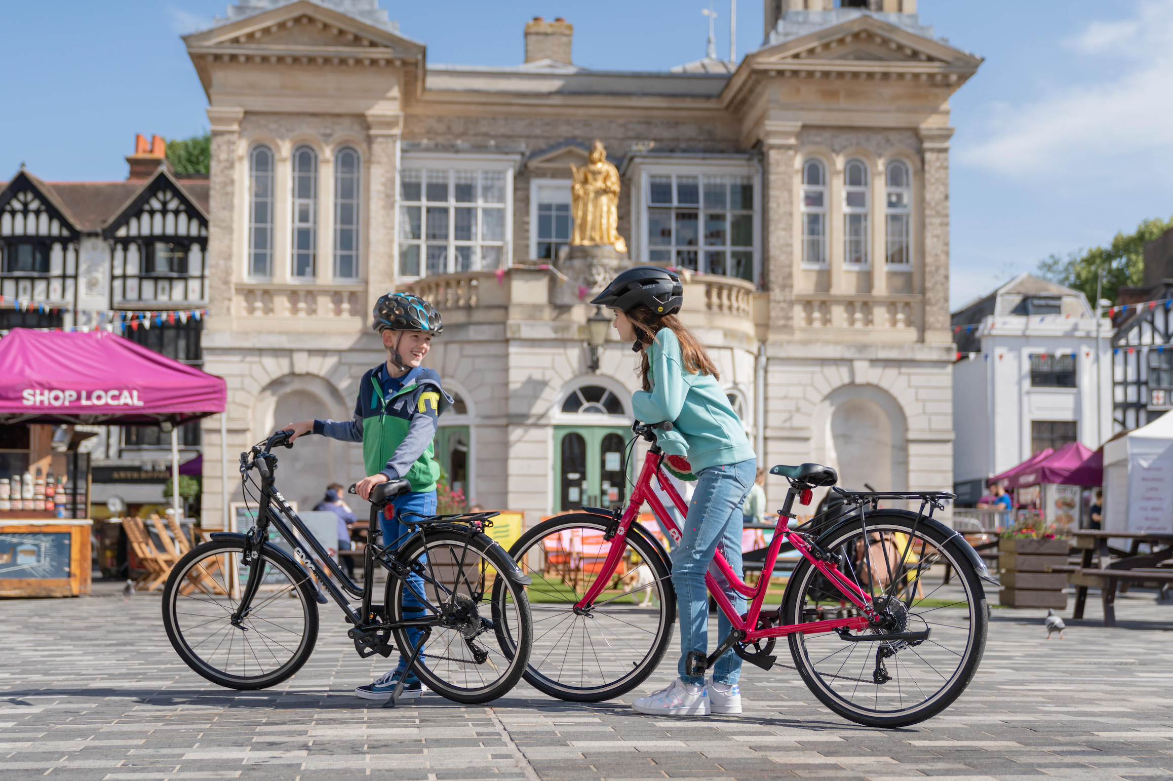 Two hcildren with Frog City bikes in town square