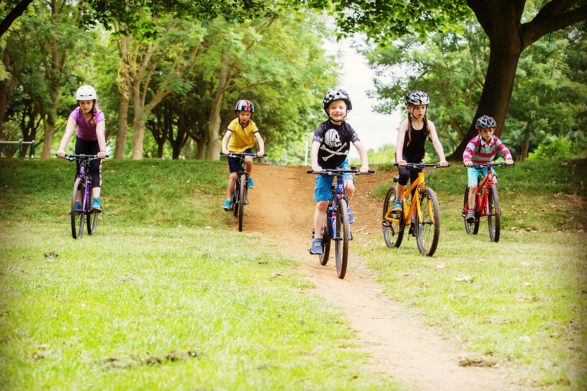 kids riding bikes together in park - bike club