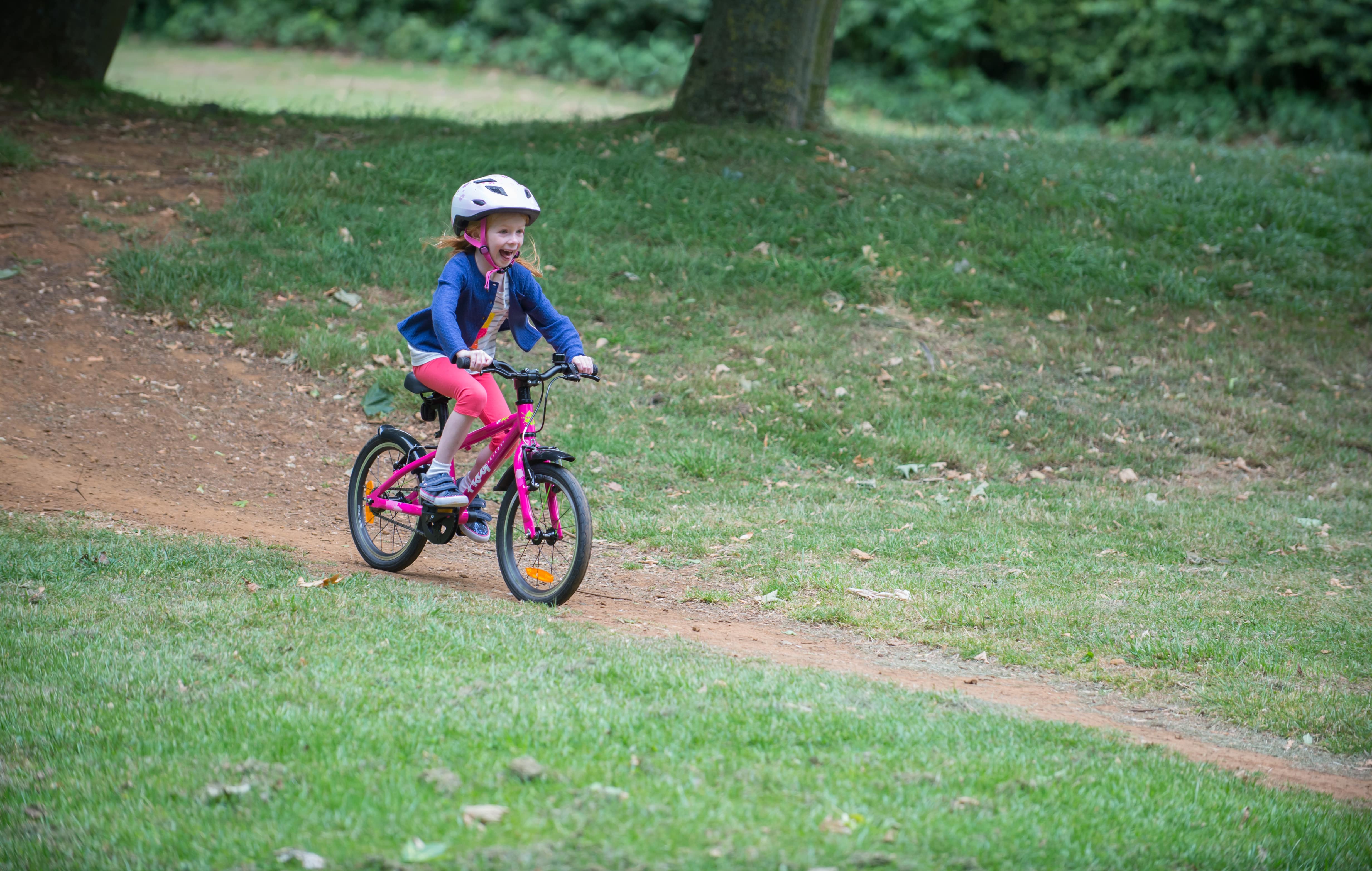 child riding a frog first pedal bike - bike club