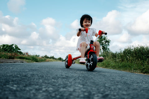 child sitting on a tricycle in the outdoors