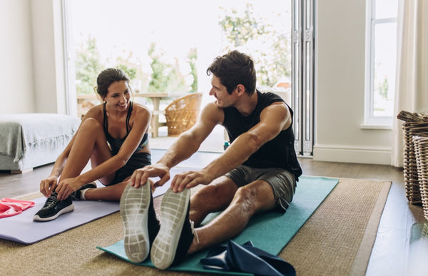 Couple exercising together. Man and woman in sports wear doing workout at home.