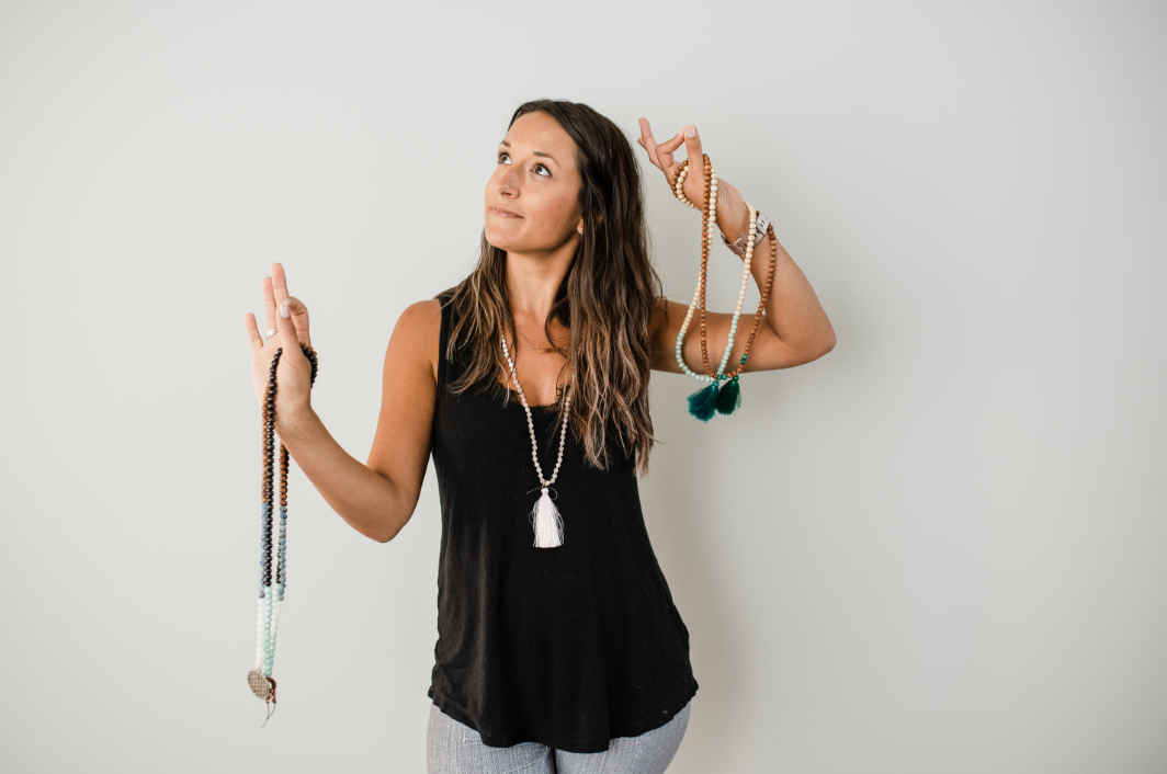 Alysia Waters of Seed + Bloom Designs holds a yoga pose while practicing mindfulness with handmade malas.
