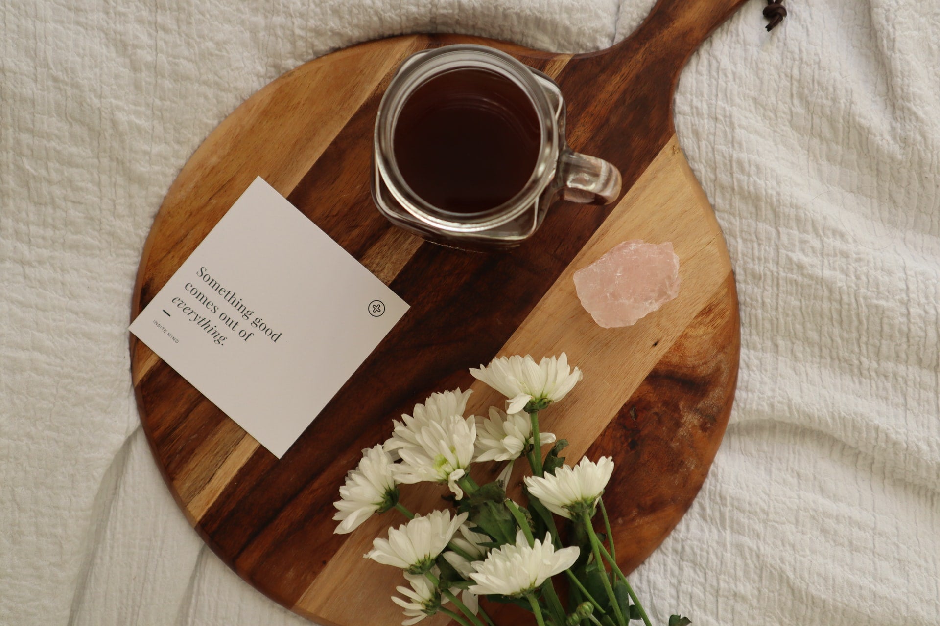 A positive affirmation card sitting beside a cup of tea and flowers.