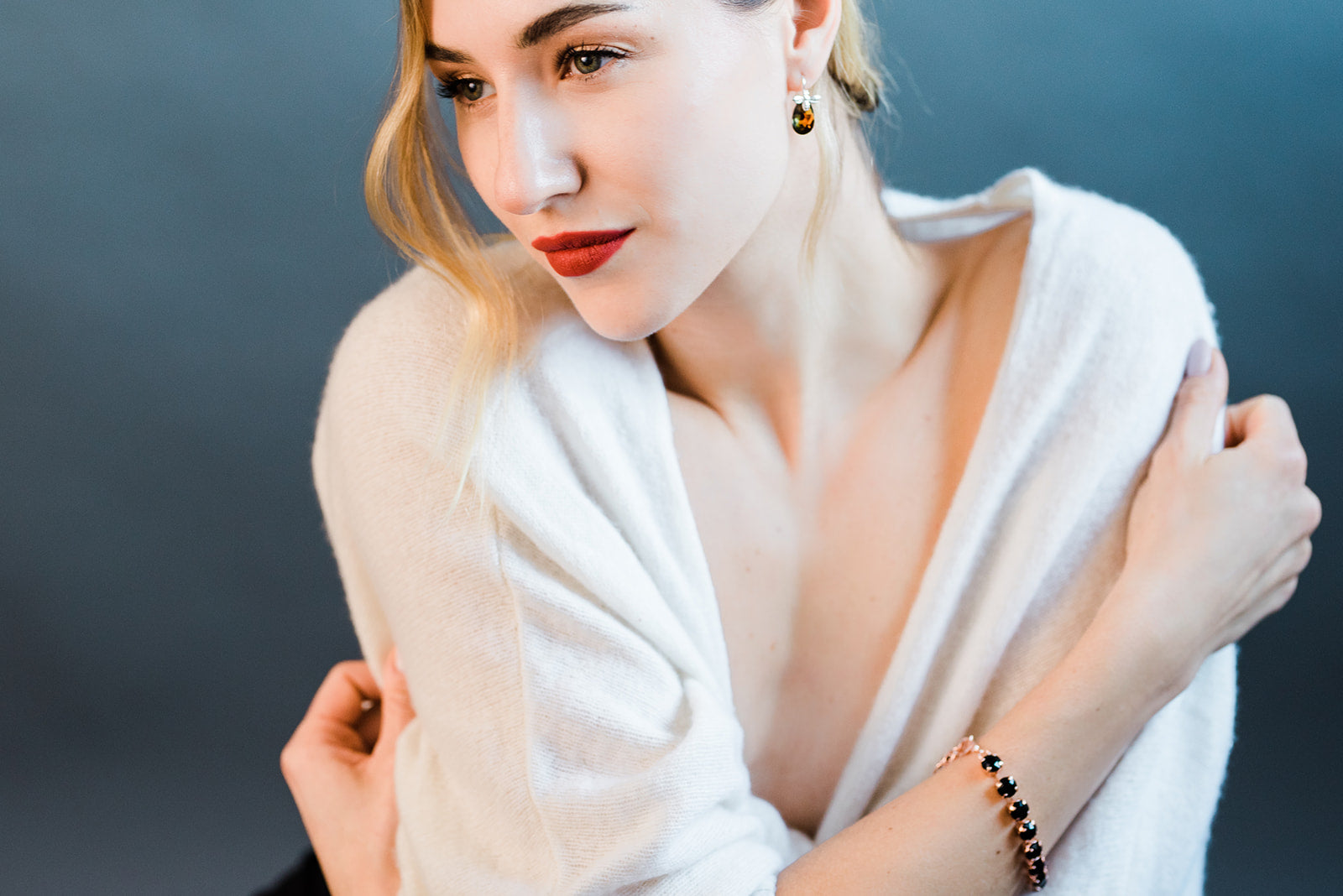 A beautiful woman wearing a white shirt and handmade Swarovski crystal bracelet and earrings.