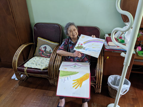 Grandma Lily holding up a painting she did 