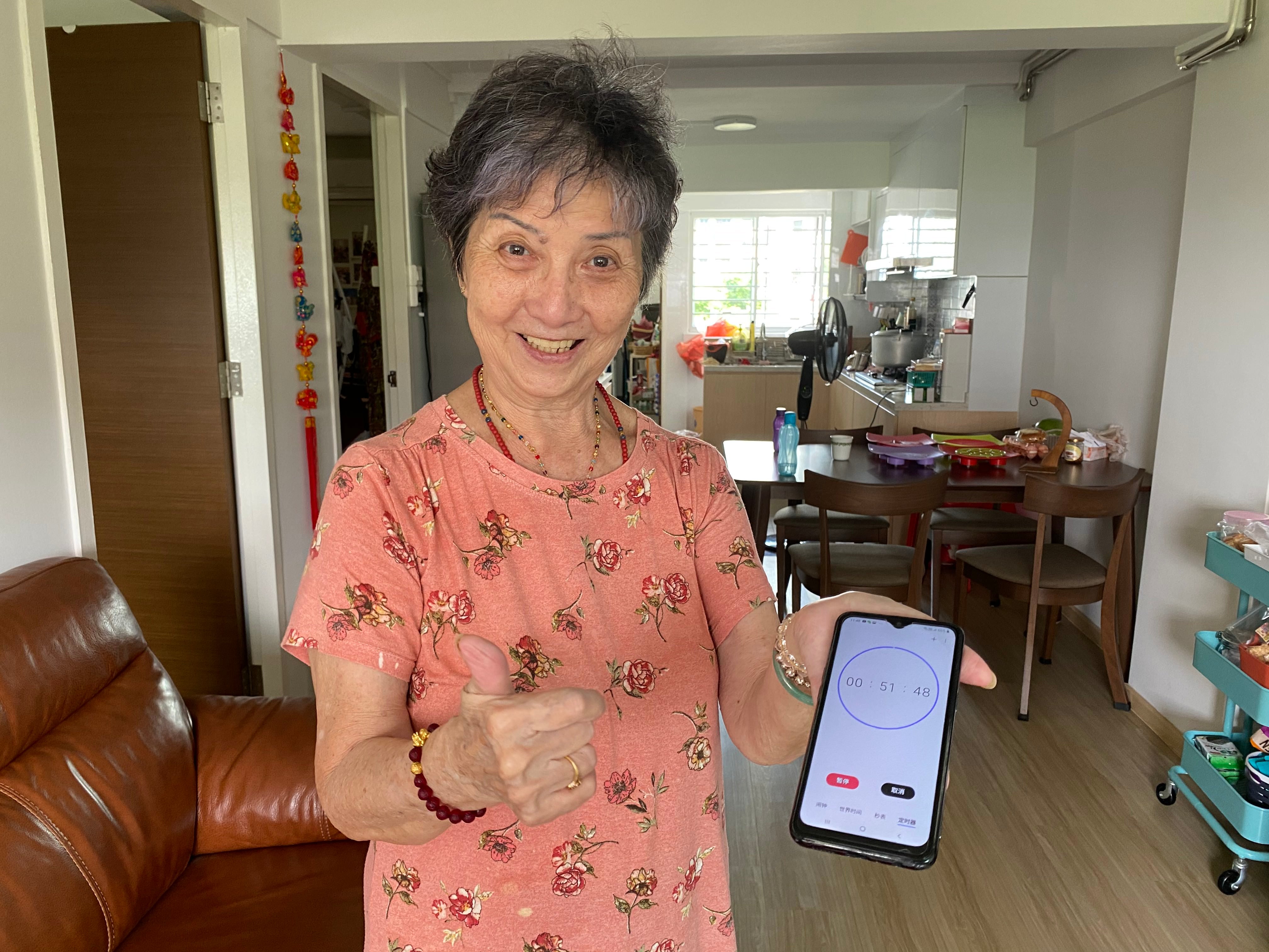 Grandma Hong showing off the new feature she learnt - setting a timer on her Phone