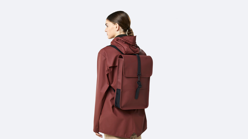 Woman wearing red Rains backpack