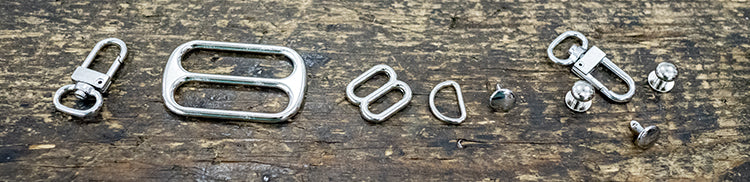 photo of rivets, buckles, and clips on wood table.