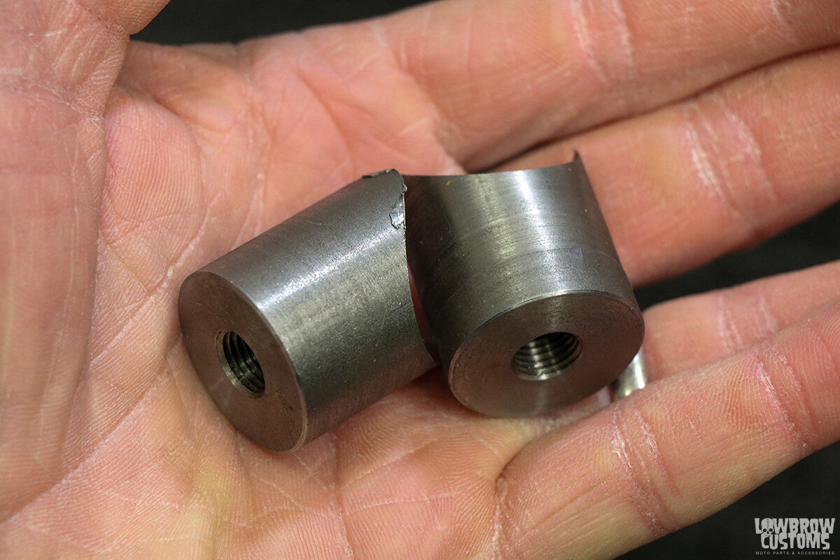 A pair of 3/4" mild steel bungs with a 2.5 degree cope to use for the upper fender mount.