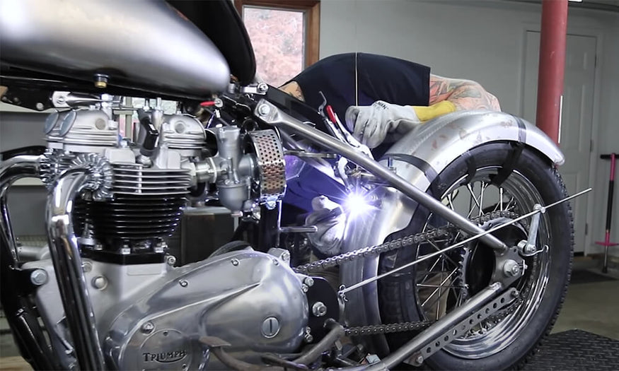 Welding the upper fender mount tab for curved fenders.