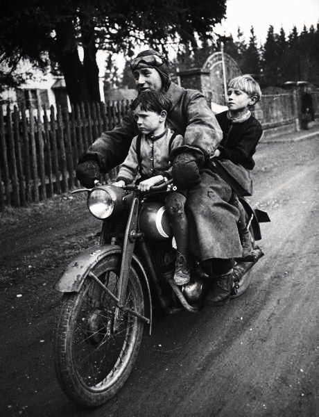 Photo by Walter Sanders. Munich, Germany, May 1949 of a man and his two boys riding on their daily commute.