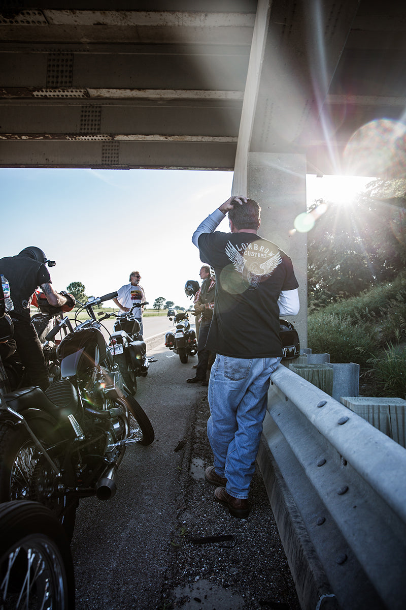 Jay filling his gas tank under an overpass. Lowbrow Customs - Cross Country 2016