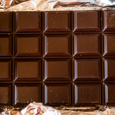 Image shows a bar of chocolate wrapped in gold foil.