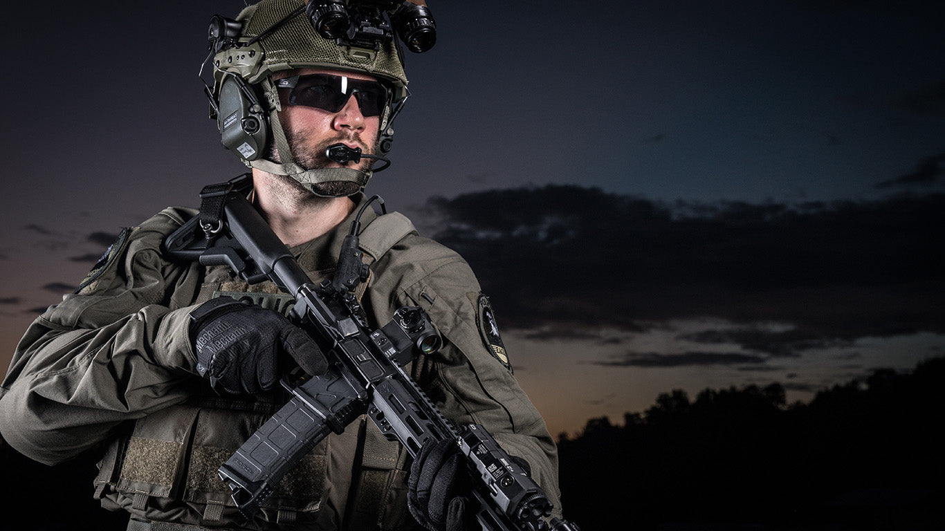 Tactical personnel geared up with Mechanix Wear Specialty Vent Covert Tactical Gloves gripping a firearm during a night operation.