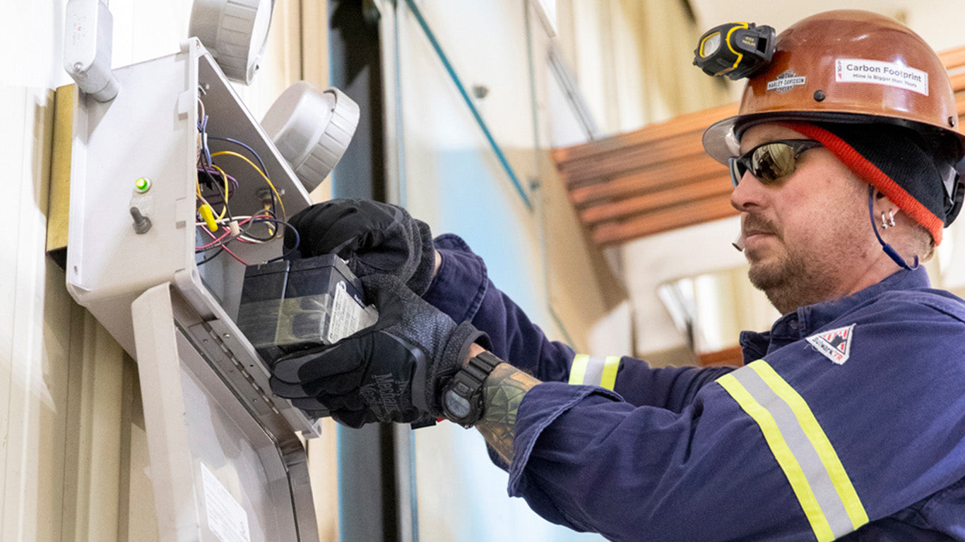 Mechanix Wear ColdWork FastFit gloves laid on a workbench among tools, embodying rugged utility for maintenance tasks.