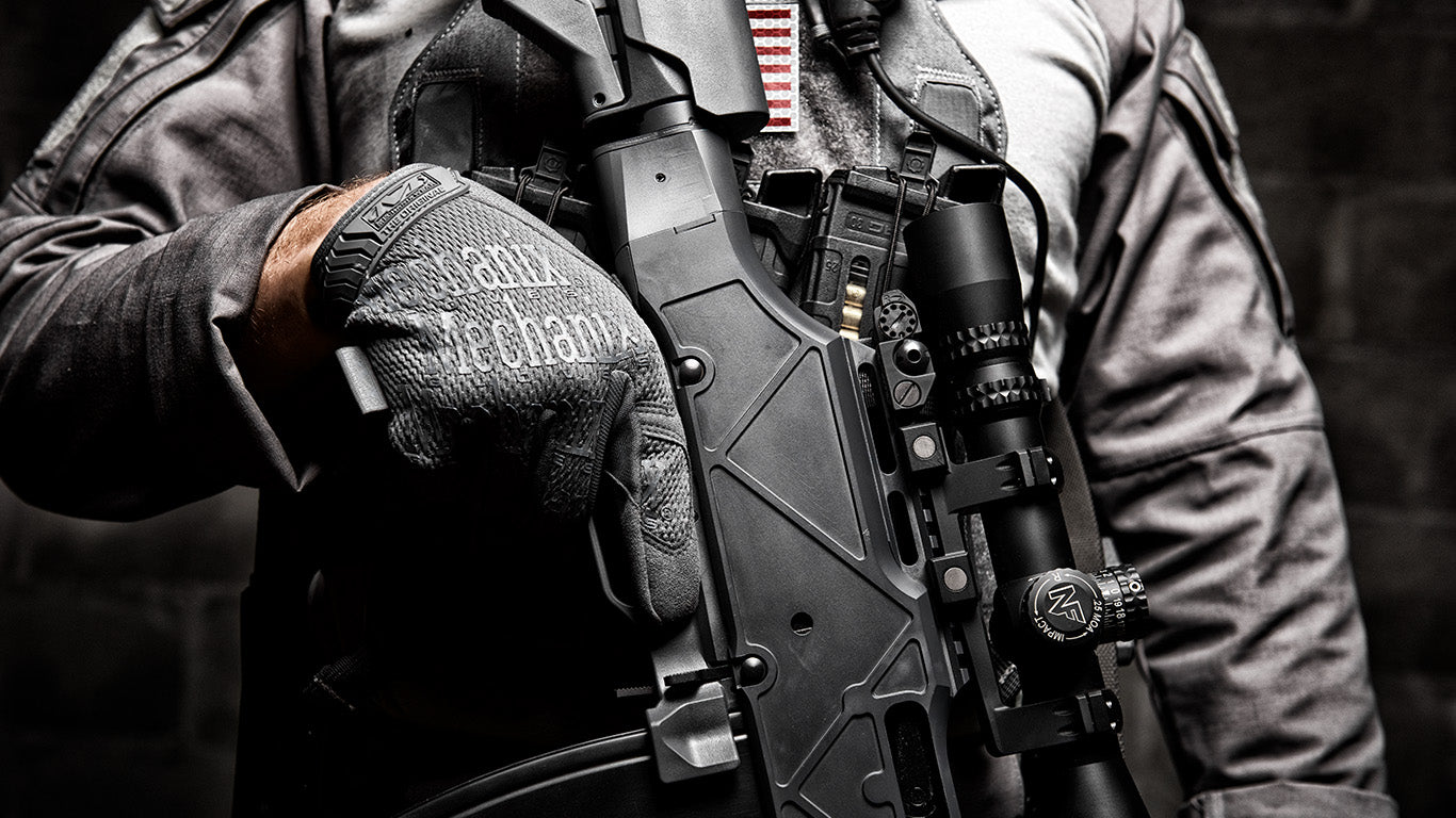 Armed professional showcasing Mechanix Wear The Original Wolf Grey Tactical Gloves during active duty.