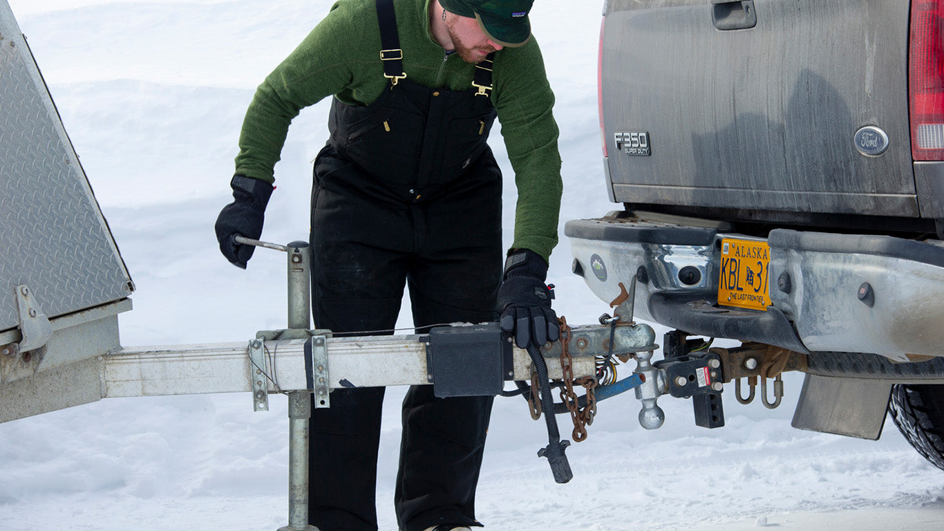 Mechanic wearing Mechanix Wear SpeedKnit™ Thermal S4DP05 gloves while working on a heavy-duty vehicle's engine.