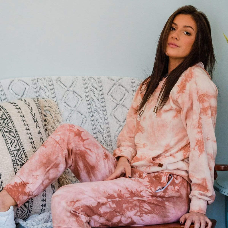 Female Model On A Sofa Wearing A Rose Marble Cloud Blend Hoodie From SLYK