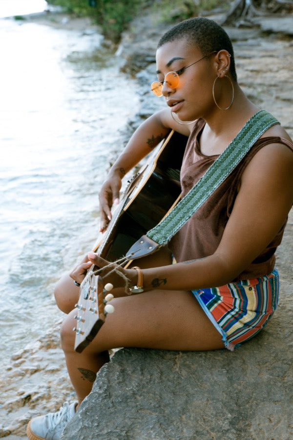 Girl with handwoven Original Fuzz guitar strap sitting by the lake in Nashville.