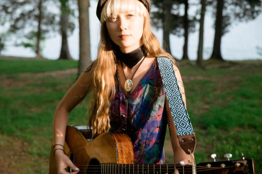 Girl with blue handwoven Original Fuzz guitar strap standing by the lake in Nashville.