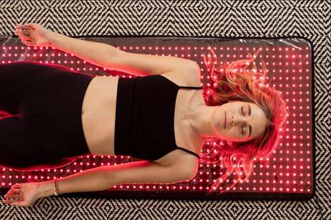 Woman Using Red Light Therapy Mat
