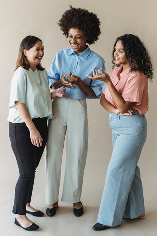 Group of women in office attire laughing together 