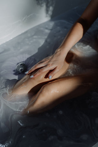 A woman sitting a bath tub full of water 