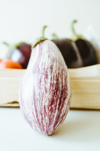 A purple Eggplant resting on a plate 